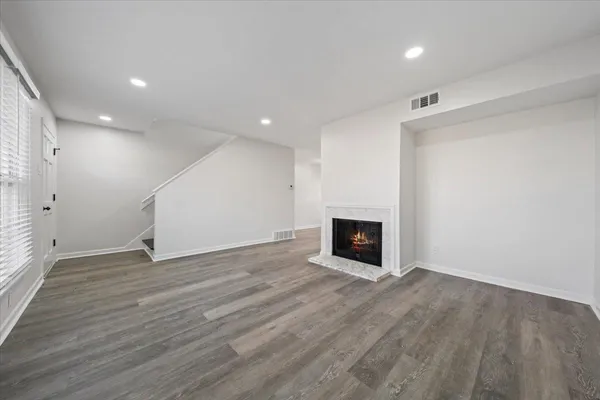 an empty room with wooden floor and fireplace