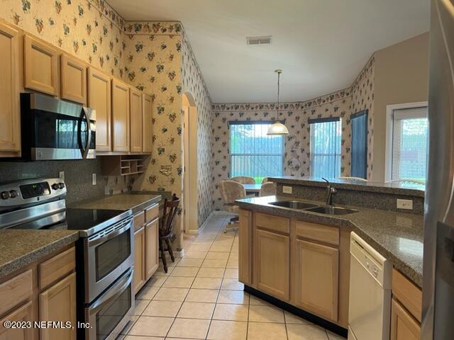 10321 Sugar Grove Road Jacksonville, FL 32221 - Photo 14 of 34 a kitchen with stainless steel appliances a stove sink and microwave