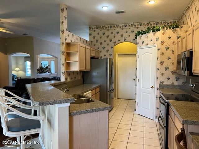 10321 Sugar Grove Road Jacksonville, FL 32221 - Photo 16 of 34 a kitchen with stainless steel appliances granite countertop a sink a stove and a refrigerator