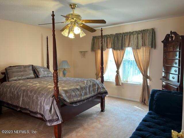 10321 Sugar Grove Road Jacksonville, FL 32221 - Photo 19 of 34 a bedroom with a bed window and a flat tv screen