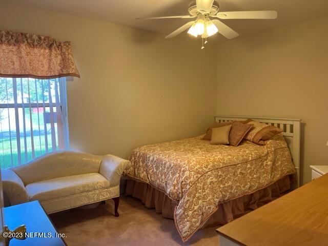 10321 Sugar Grove Road Jacksonville, FL 32221 - Photo 25 of 34 a bedroom with a bed and a chandelier
