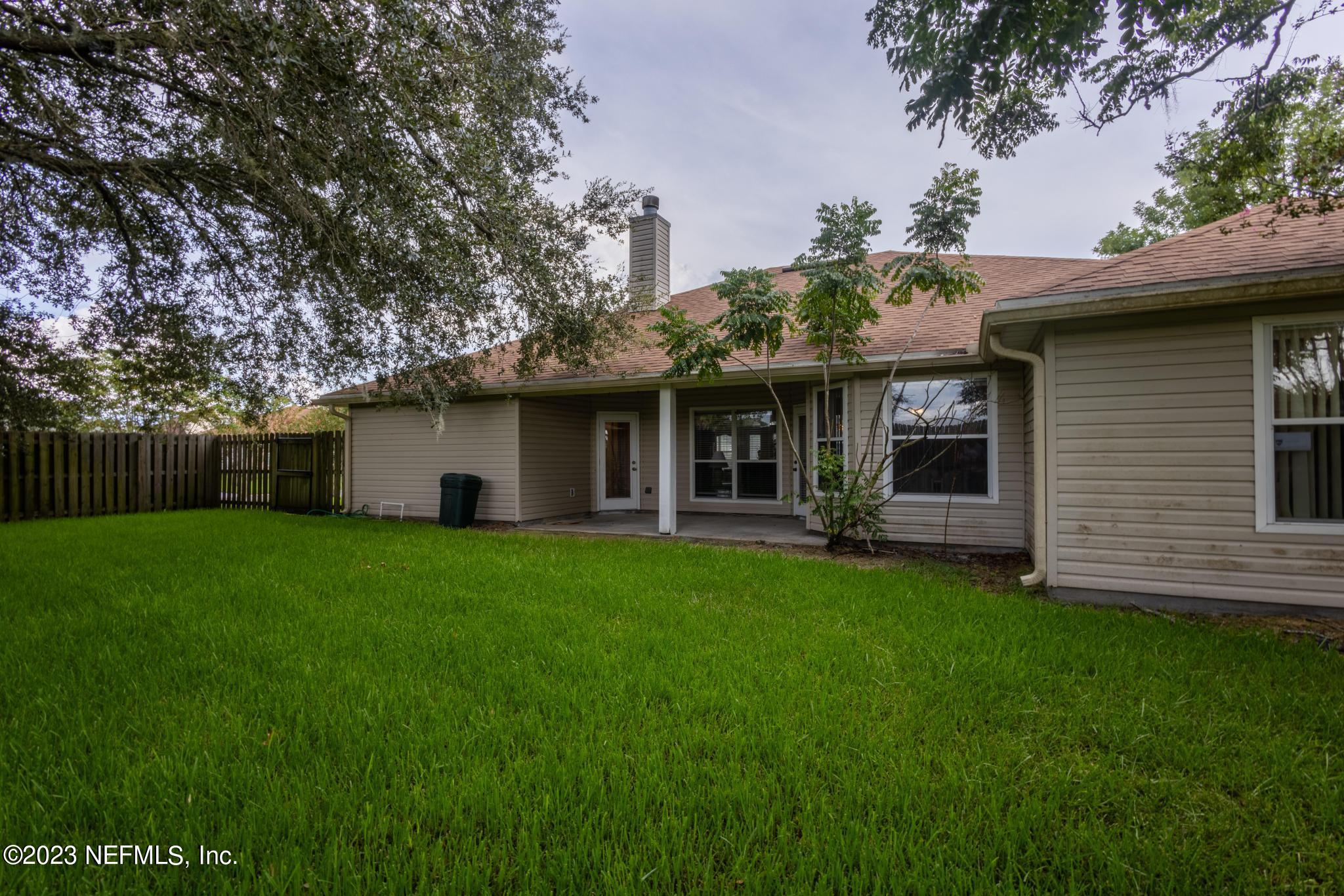 10321 Sugar Grove Road Jacksonville, FL 32221 - Photo 33 of 34 a view of a house with a yard potted plants and a large tree