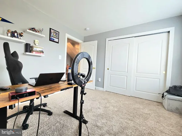 a view of a workspace with furniture and a window