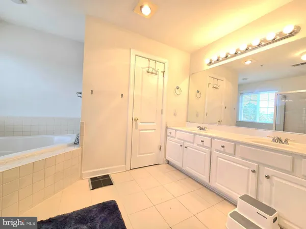 a spacious bathroom with a shower a sink and a mirror