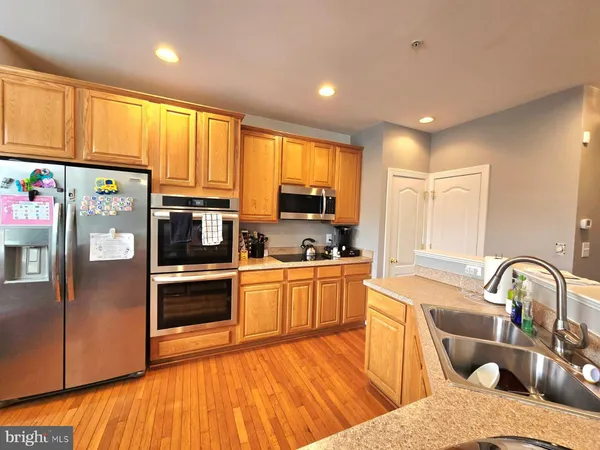 a kitchen with kitchen island granite countertop a sink cabinets and stainless steel appliances