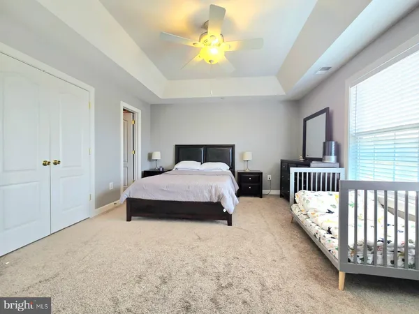 a spacious bedroom with a bed chandelier and a window