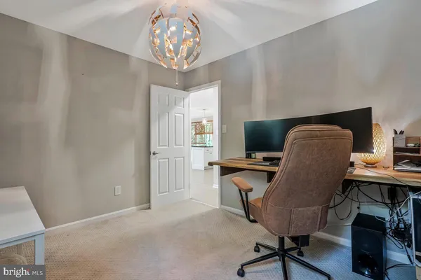 a view of a workspace with furniture and a chandelier