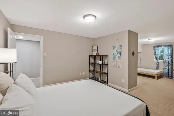 a bedroom with a bed and a view of living room