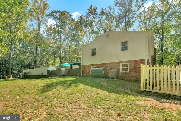 a view of a house with backyard and trees