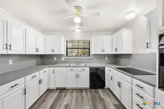a kitchen with cabinets stainless steel appliances a sink and a window
