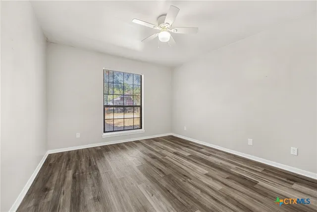wooden floor in an empty room with a window