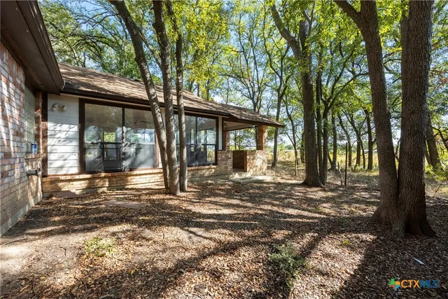 a view of a house with backyard and sitting area