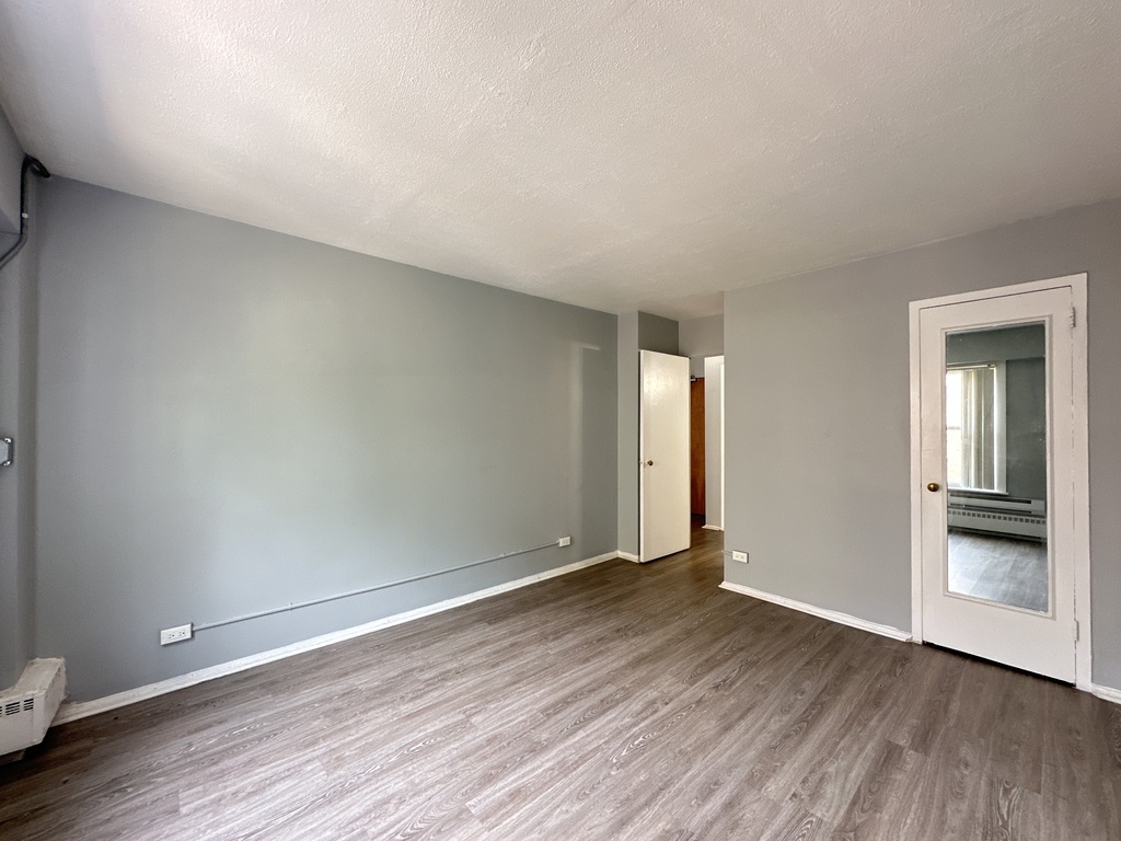 1040 West Hollywood Avenue, Unit 520 Chicago, IL 60660 - Photo 13 of 20 a view of an empty room with wooden floor and a window