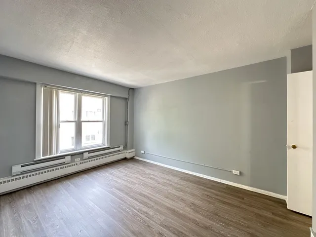 a view of an empty room with wooden floor