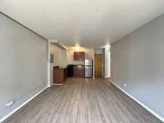 a view of a kitchen with a sink and a refrigerator