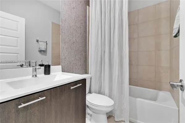 a bed sitting in a bedroom next to a window and a chandelier