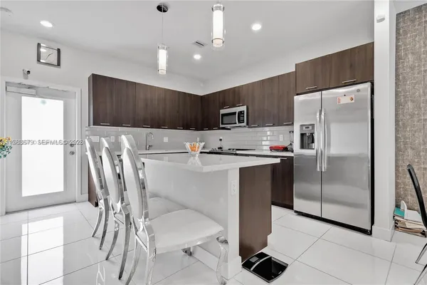 a kitchen with stainless steel appliances a refrigerator sink and microwave