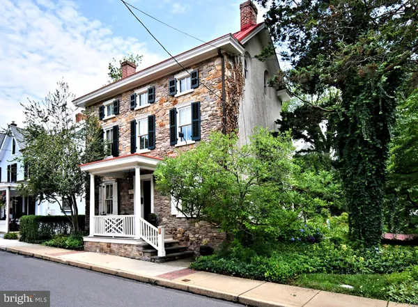 a front view of a house with a tree
