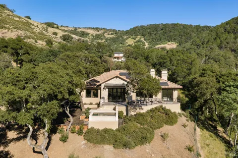 an aerial view of a house with a mountain