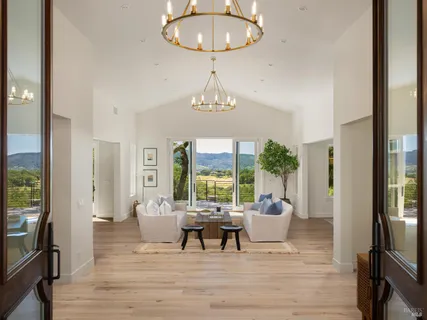 a living room with furniture a window and a chandelier