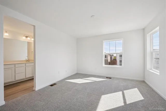 an empty room with windows and cabinet