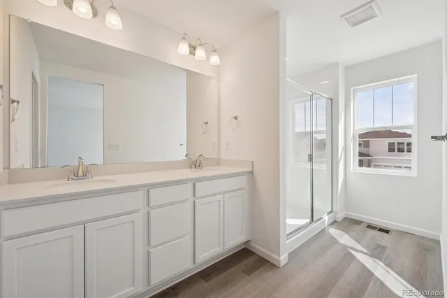 a bathroom with double sink and a mirror