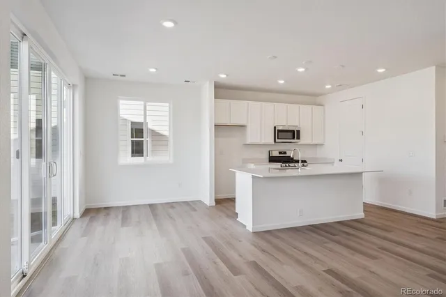 a view of kitchen with wooden floor and electronic appliances