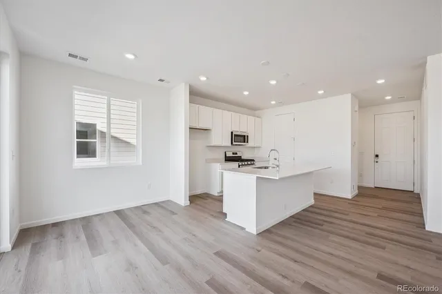 a view of kitchen with wooden floor and electronic appliances
