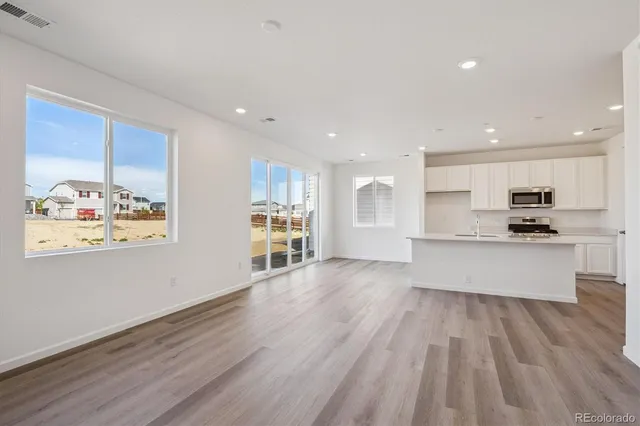 a large kitchen with stainless steel appliances wooden floors and wooden cabinets