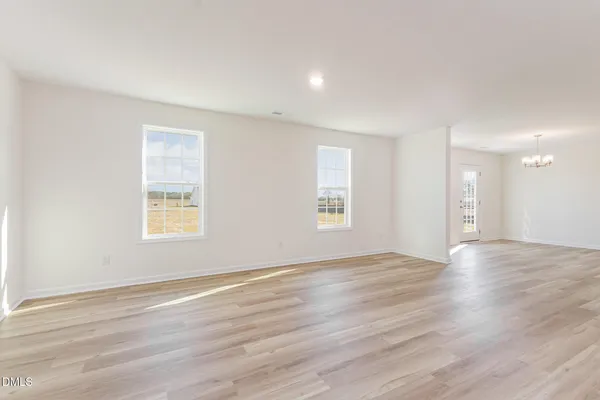 a view of an empty room window and wooden floor