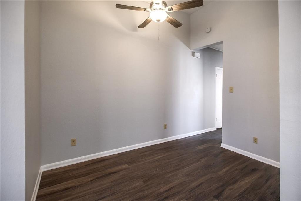 2529 Rio Grande Street, Unit 93 Austin, TX 78705 - Photo 5 of 19 Room featuring dark wood-style flooring, light grey walls, white baseboards, and a ceiling fan with integrated lighting