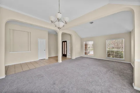a view of a livingroom with a chandelier fan and windows