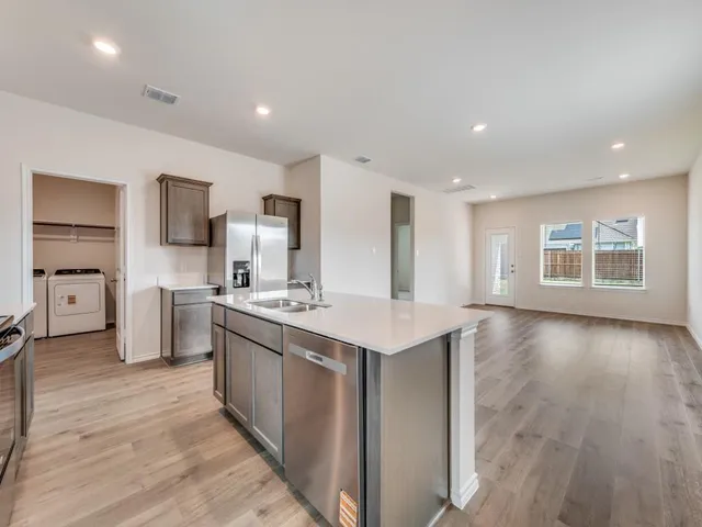 a kitchen with stainless steel appliances granite countertop a sink stove and refrigerator