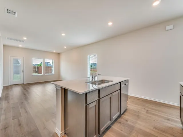 a kitchen with a sink cabinets and wooden floor