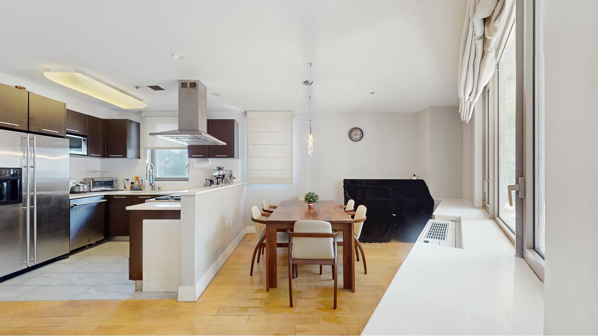 64-05 Yellowstone Boulevard, Unit TH105 Queens, NY 11375 - Photo 3 of 25 a kitchen with stainless steel appliances kitchen island granite countertop a sink refrigerator and cabinets