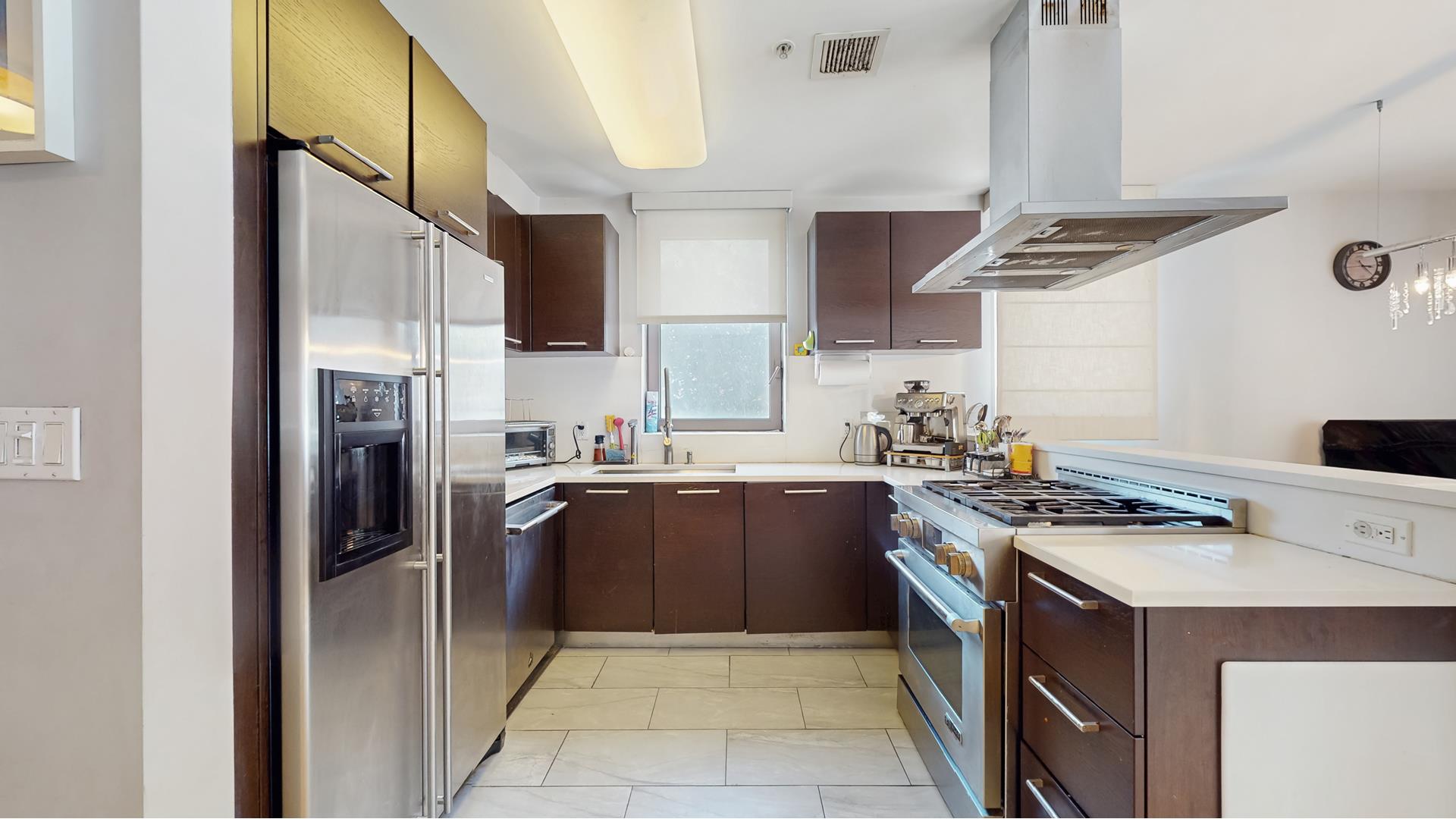 64-05 Yellowstone Boulevard, Unit TH105 Queens, NY 11375 - Photo 5 of 25 a kitchen with stainless steel appliances granite countertop a stove a refrigerator and a sink