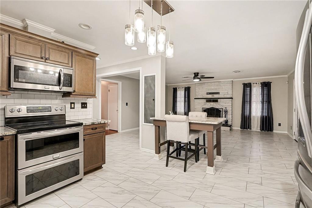 254 County Line Road Fayetteville, GA 30215 - Photo 20 of 51 a open kitchen with stainless steel appliances kitchen island granite countertop a stove top oven a sink a dining table and chairs