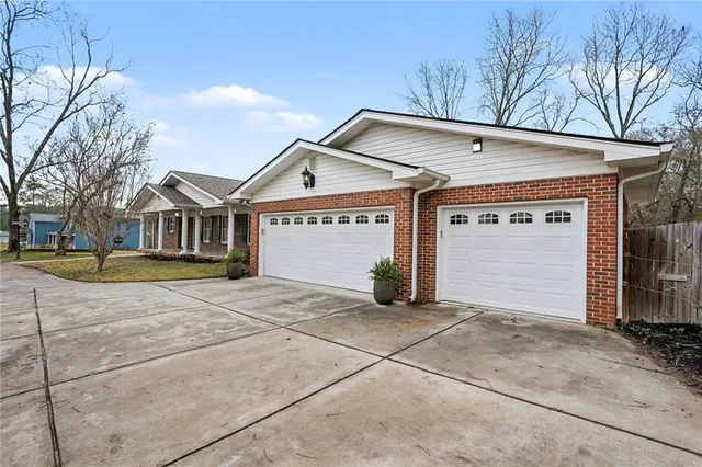 a view of a house with a garage and large tree