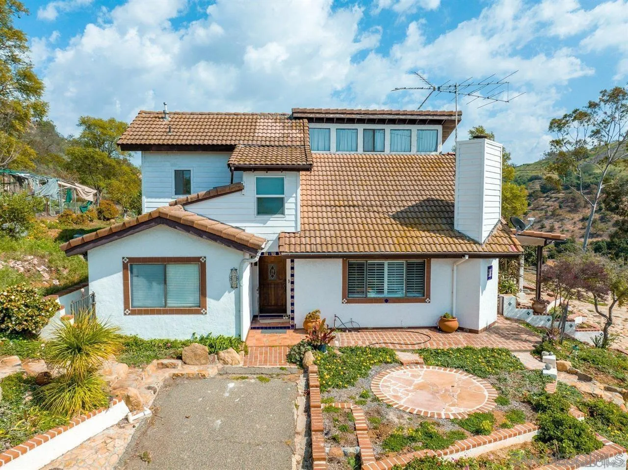 9202 Moon Ridge Road Fallbrook, CA 92028 - Photo 2 of 44 a view of a white house with large windows and a table and chairs