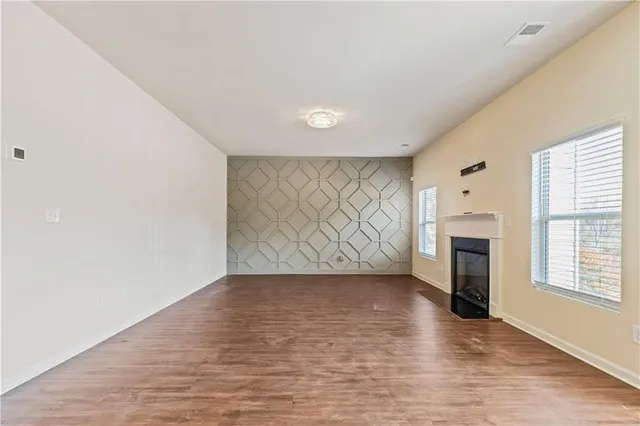 a view of an empty room with a fireplace and a window