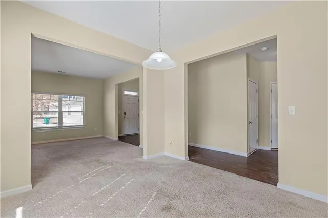 an empty room with windows and chandelier