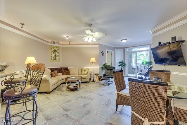 a living room with furniture a dining table and a chandelier