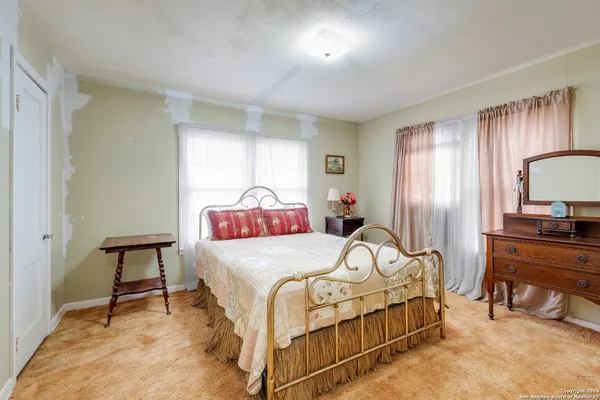 a bedroom with a bed a table and a dresser