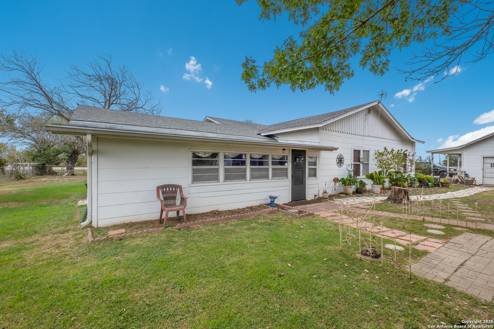 461 Highway 173 Devine, TX 78016 - Photo 21 of 27 a front view of a house with a garden and yard