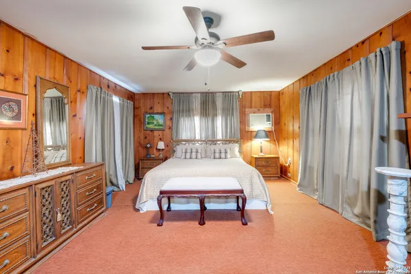 a bedroom with furniture and a large window