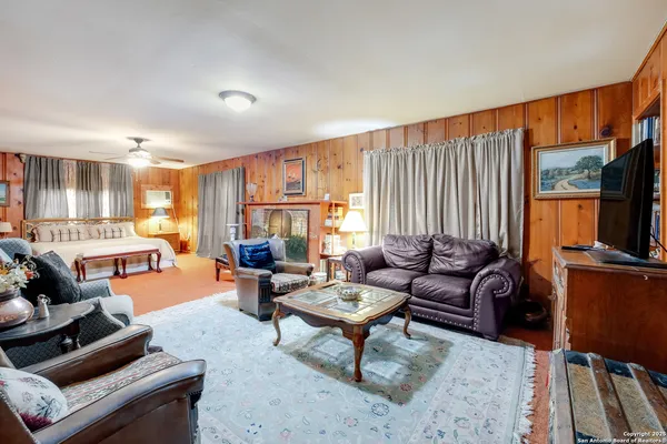 a living room with furniture a flat screen tv and a large window