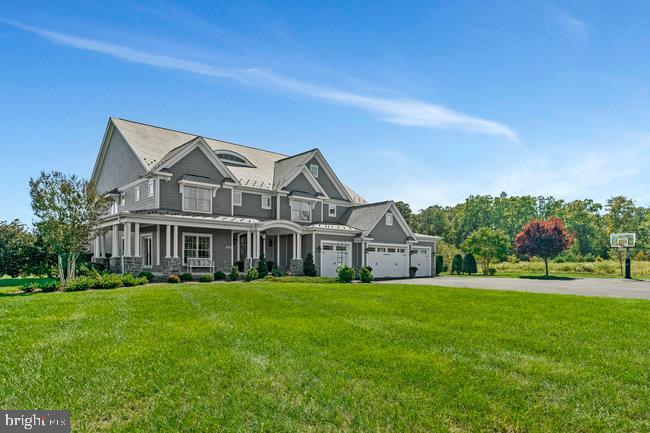 a view of a house with a big yard and large trees