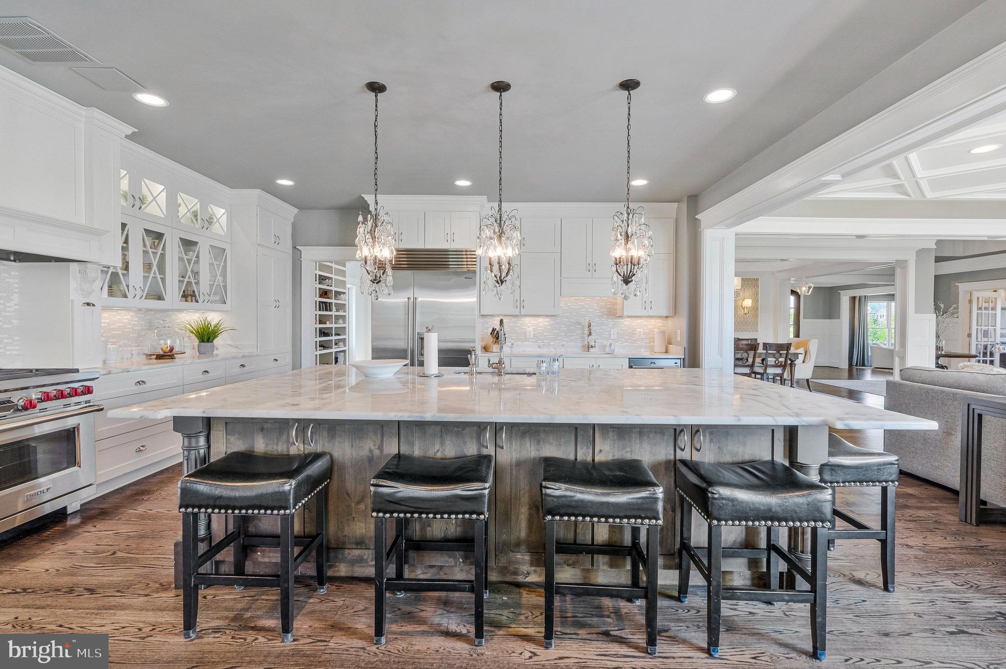 41865 Scotchbridge Place Ashburn, VA 20148 - Photo 35 of 93 a kitchen with kitchen island granite countertop a dining table chairs and white cabinets