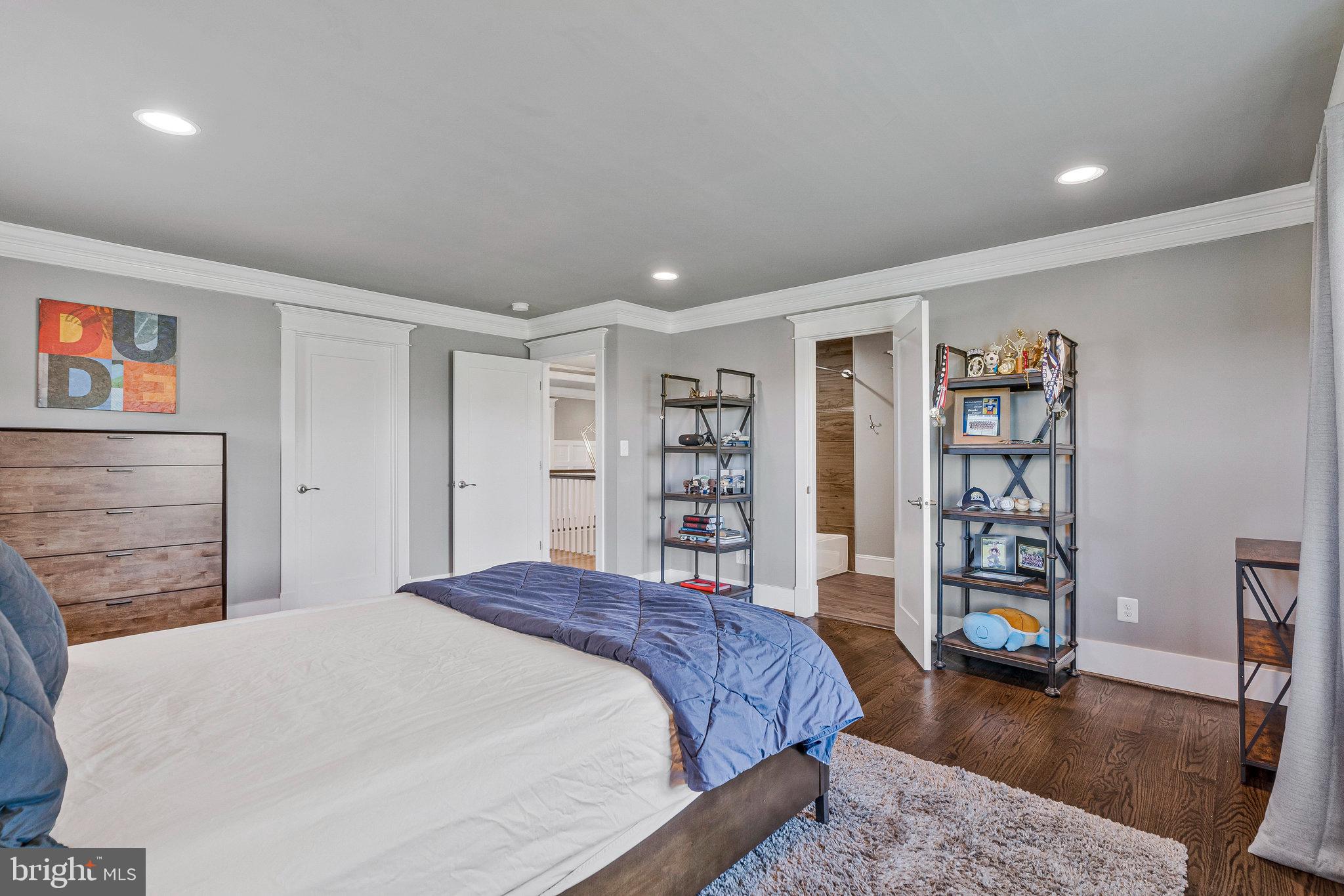 41865 Scotchbridge Place Ashburn, VA 20148 - Photo 56 of 93 a spacious bedroom with a bed a dresser and book shelf