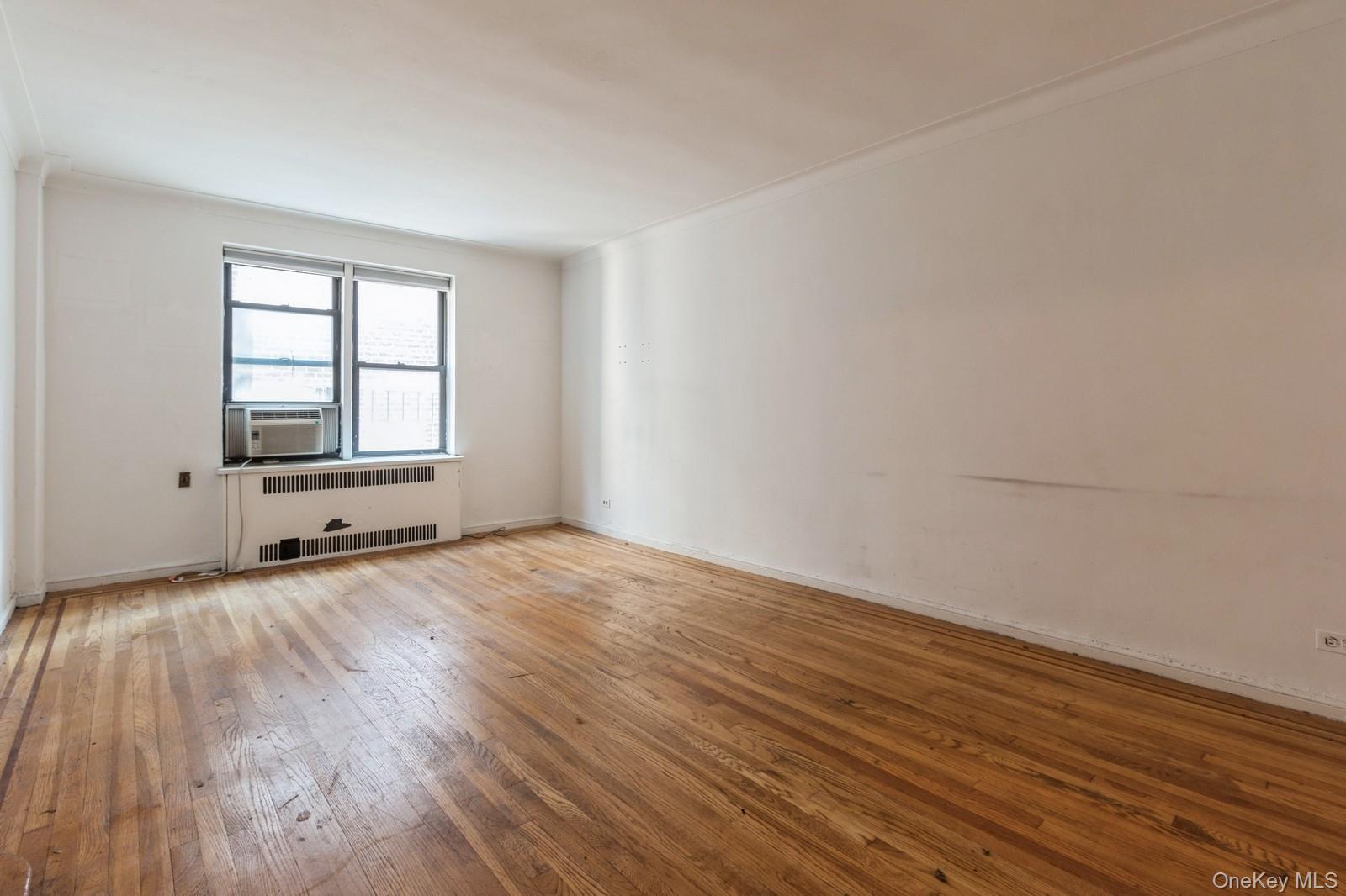 405 West 57th Street, Unit 4C Manhattan, NY 10019 - Photo 14 of 15 a view of an empty room with wooden floor and a window
